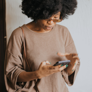 solo creative founder checking her phone, done for you business setup for service providers